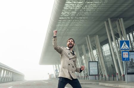 Cheerful and happy businessman is actively dancing on a airport.