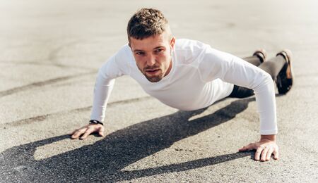 Man training push up outdoors. Handsome man doing push-ups outdoors.の写真素材