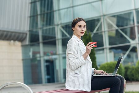 Young woman holding credit card and using laptop computer. Online shopping concept.