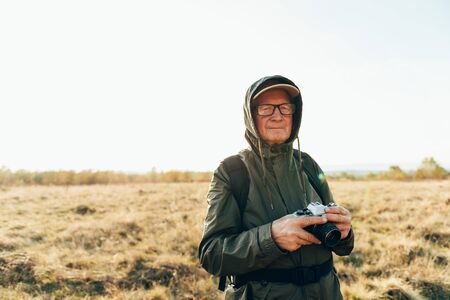 Mature man photographing the autumn season