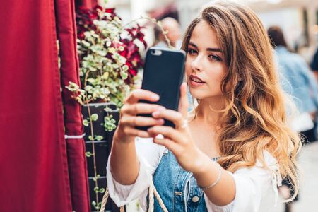 Image of pretty emotional happy girl sitting in cafe talking by mobile phone.の写真素材