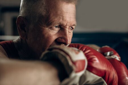 An elderly boxer in the ring thinks about his defeatの写真素材