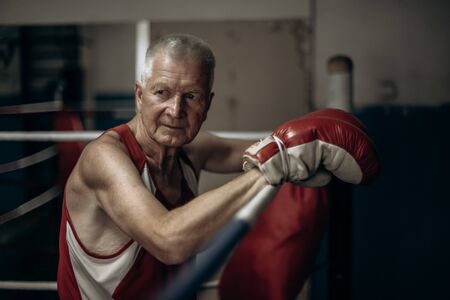 Elderly boxer thinks about tactics before a fight in the ring.の写真素材