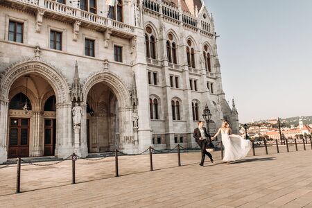 Bride holds groom's hand walking across the street in New York.の写真素材