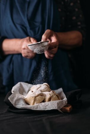 Woman puts powdered sugar on top of a traditional apple cookiesの写真素材