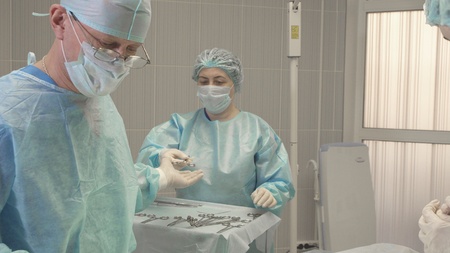 a nurse helps a surgeon during an operation