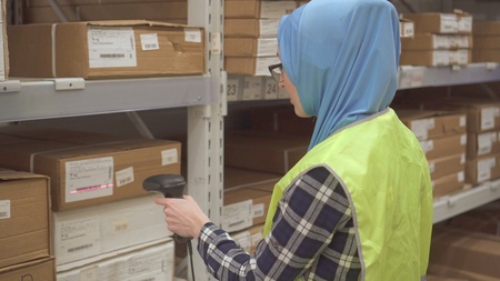 Girl store worker with barcode scanner of goodsの写真素材