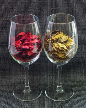Two glasses filled with red and gold flower petals.の写真素材