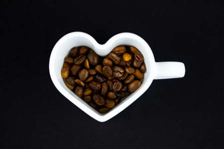 A white heart-shaped mug, inside a coffee bean.の写真素材
