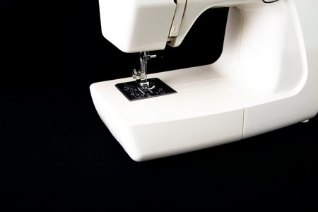 White sewing machine on a black background.
