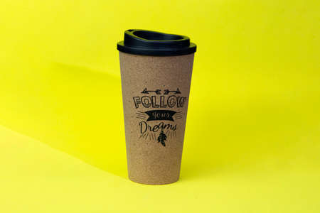 A glass of coffee on a yellow background.