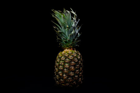 Ripe juicy pineapple on a black background.の写真素材