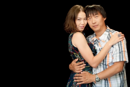 Asian couple standing together isolated on the black backgroundの写真素材