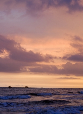 Image of exotic sky over sea at sunset. Increasing waves reflects sunlight with clouds.の写真素材