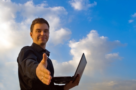 Young successful businessman working on laptop. It his internet business, through wireless technologyの写真素材