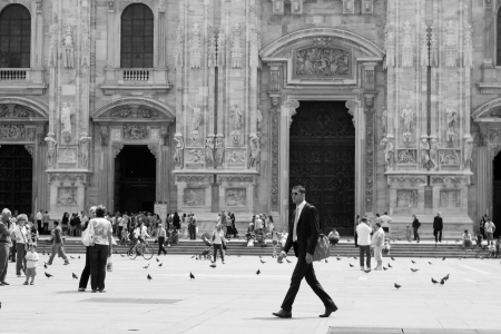 MILAN, June 24, 2009: A businessman in black walking before which so many people on display at Duomo cathedral on June 24, 2009 Milan, Italyのeditorial素材