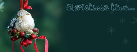 Christmas decoration of handmade bird on the green background having much space for textの写真素材