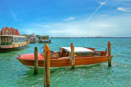 Picture of a parked boat for a tour of the canal in Venice on the background of emerald green waters, Italy.の写真素材