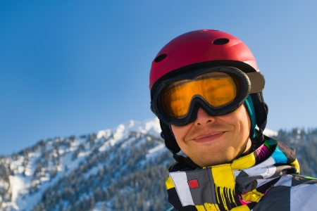 An image with a portrait of a snowboarder wearing a helmet and glasses on the background of high snow-capped Alps in Grindelwald, Swissの写真素材