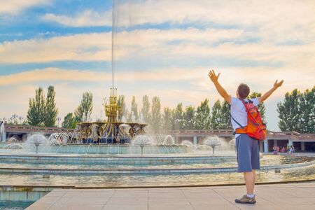 Image of big fountain in National Park of first President of Kazakhstan. Young tourist admiring the sunset scenery. Almatyのeditorial素材