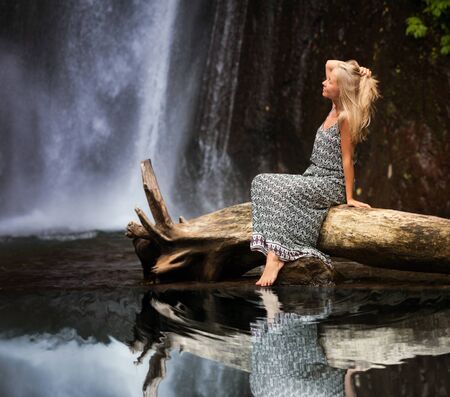 young woman traveling near the waterfall, Indonesiaの写真素材