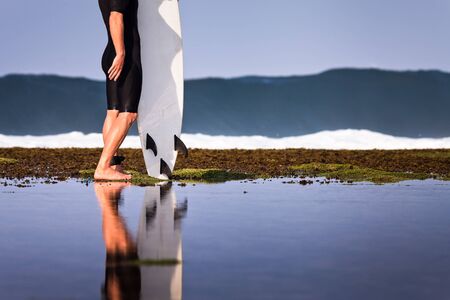 Surfer with surfboard on a coastline of Sumbawa, Indonesiaの写真素材