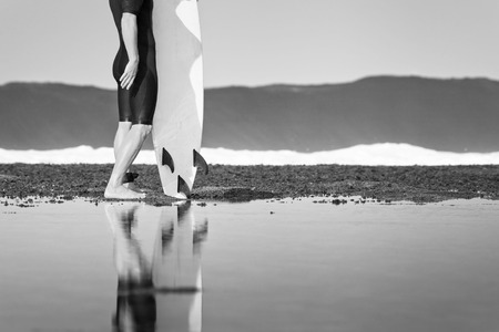 Surfer with surfboard on a coastline of Sumbawa, Indonesiaの写真素材