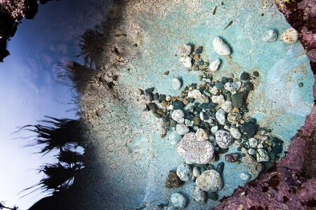 Blue water background with stone at the ocean