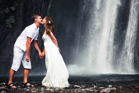 kissing couple just married near the waterfallの写真素材