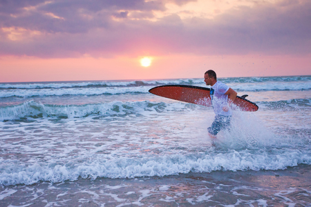 surfer running on coast in Indonesia, Bali, Kutaの写真素材
