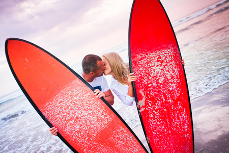 Couple of surfers kissing on coast in Indonesia, Bali, Kutaの写真素材