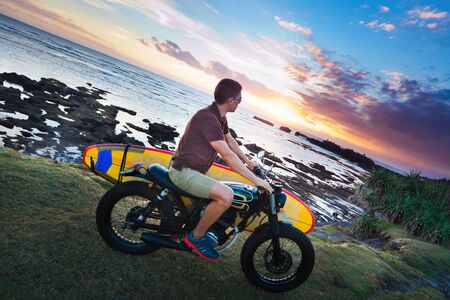 Man on motorcycle with surfboard at Baliのeditorial素材