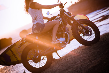Girl on motorcycle with surfboard at Baliの写真素材