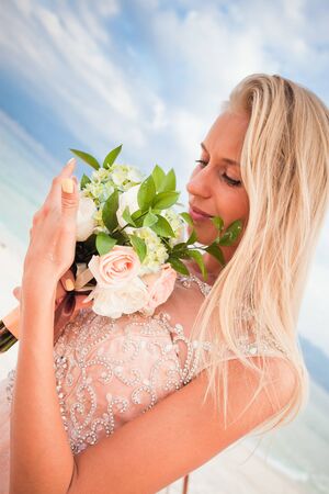 Bride with wedding bouquet at blue sky backgroundの写真素材