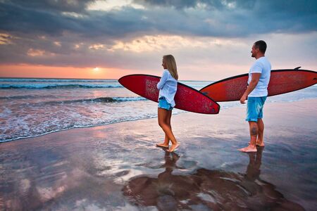 Couple of surfers walking on coast in Indonesia, Bali, Kutaの写真素材