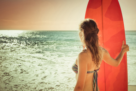 surfer girl with long board watching to the seaの写真素材