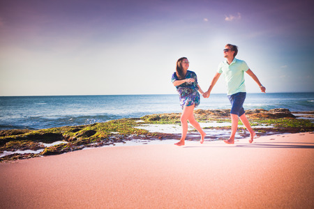 happy couple running at the beachの写真素材