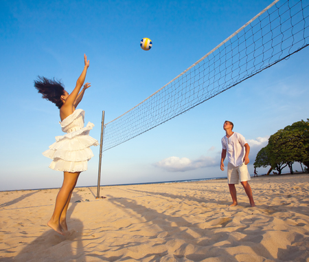 couple playing volleyball at the beachの写真素材