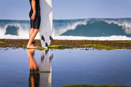 Surfer with surfboard on a coastline of Sumbawa, Indonesiaの写真素材