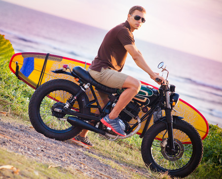 Man on motorcycle with surfboard at Baliの写真素材