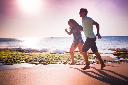 happy couple running at the beachの写真素材