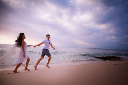 happy couple running at the beachの写真素材