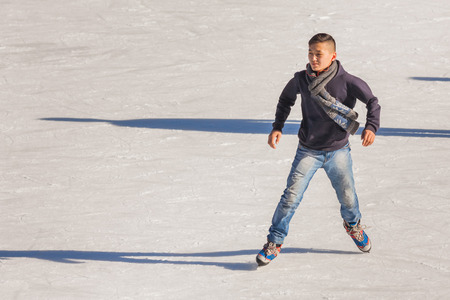 Image of young man who are ice skating at the ice rink outdoors at Medeoの写真素材