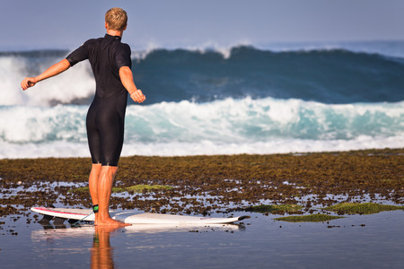 photo of exercises man - surfer at the beachの写真素材