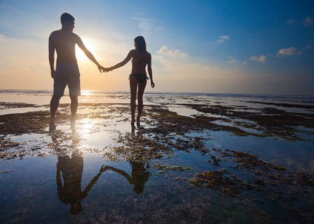 honeymoon couple walking at blue beachの写真素材