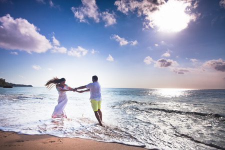 wedding couple jogging and dancing on the beachの写真素材