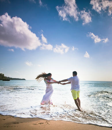 wedding couple jogging and dancing on the beachの写真素材