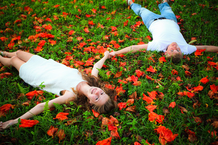 happy young couple lying on the background of flowersの写真素材