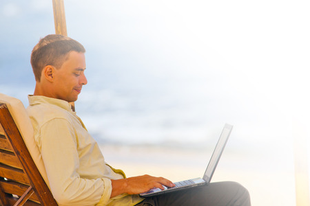 businessman enjoys his remotely work near sea, there is copy space for any textの写真素材