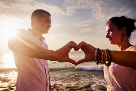 young couple with concept of love sign by handsの写真素材